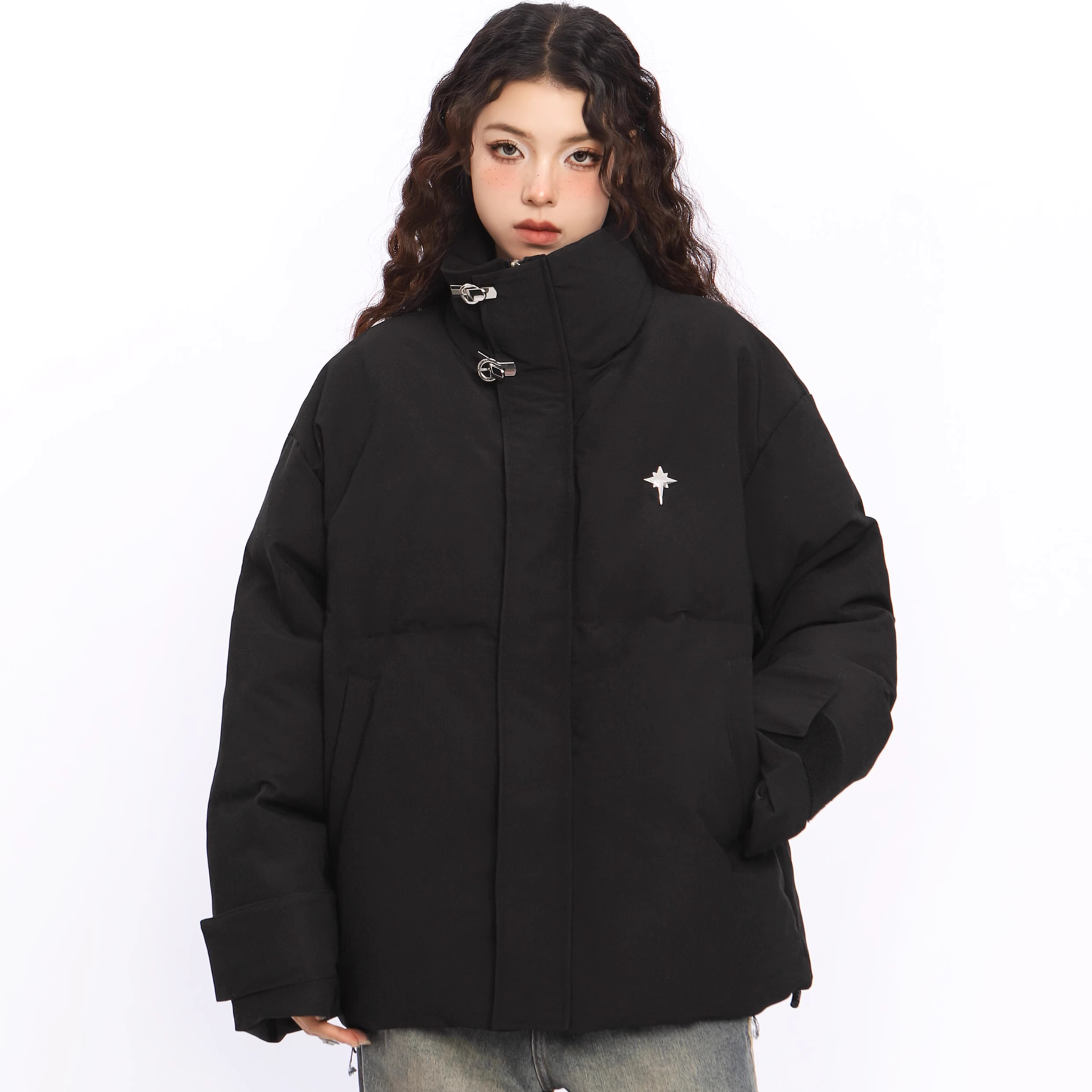 Person wearing a black puffer jacket with a small white logo on a white background