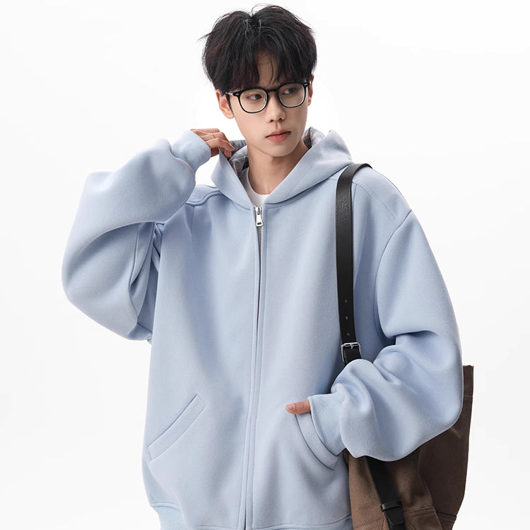 Person wearing a light blue hoodie with a brown bag on a white background